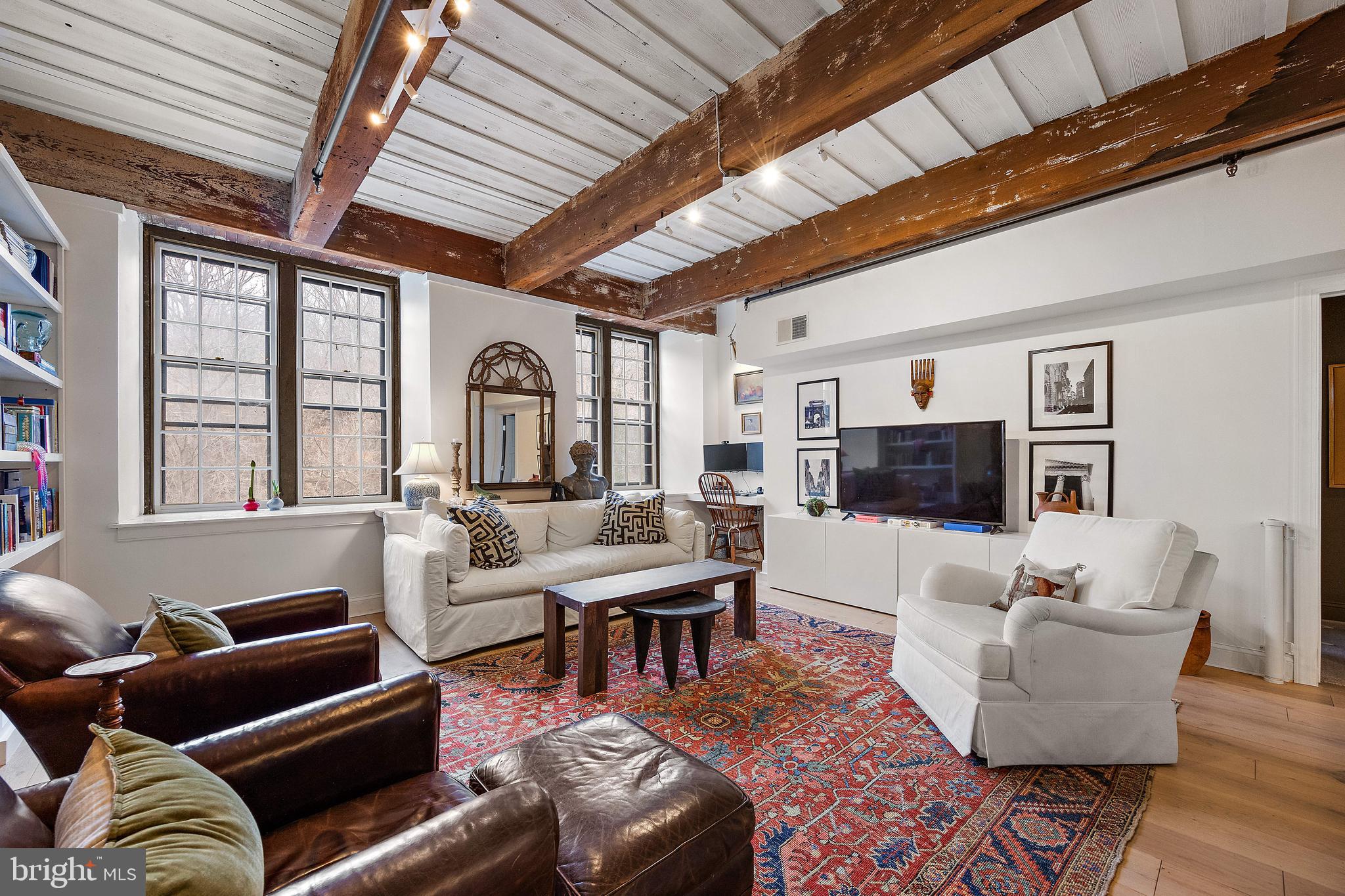 49 Bancroft Mills Road, Unit 2B Wilmington, DE 19806 - Photo 8 of 18 a living room with furniture a flat screen tv and a large window