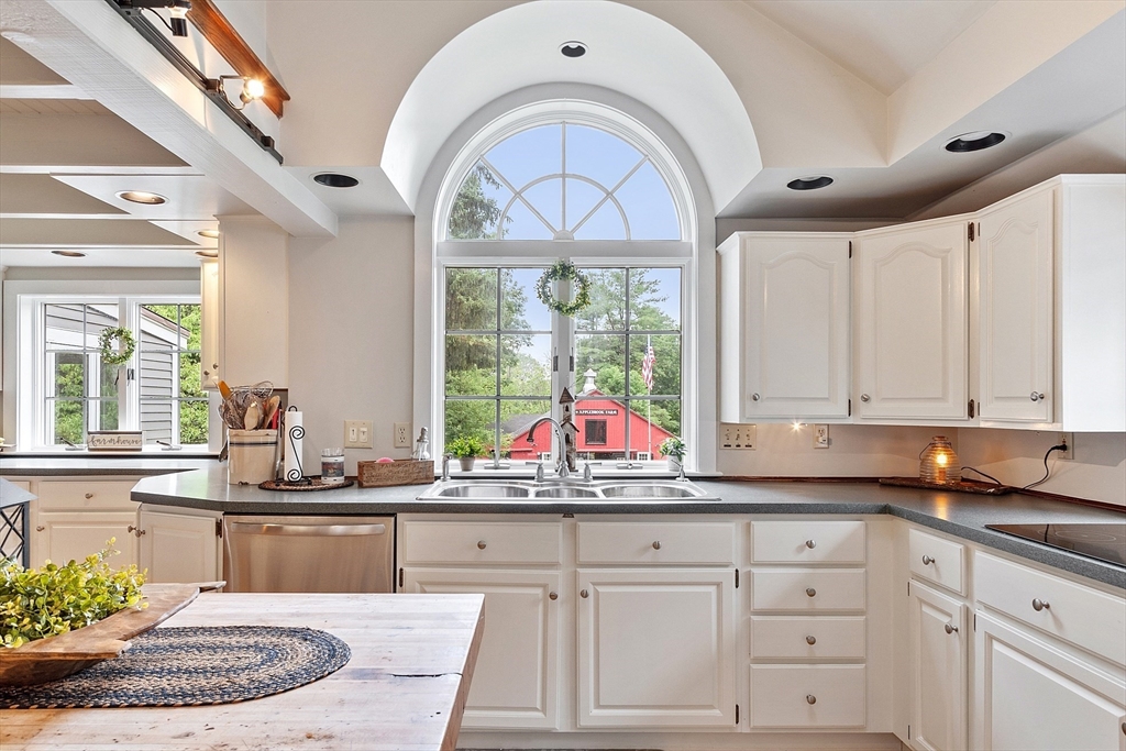 10 Garrison Street Groveland, MA 01834 - Photo 3 of 42 a kitchen with kitchen island granite countertop a stove a sink and dishwasher wooden cabinets with a large window