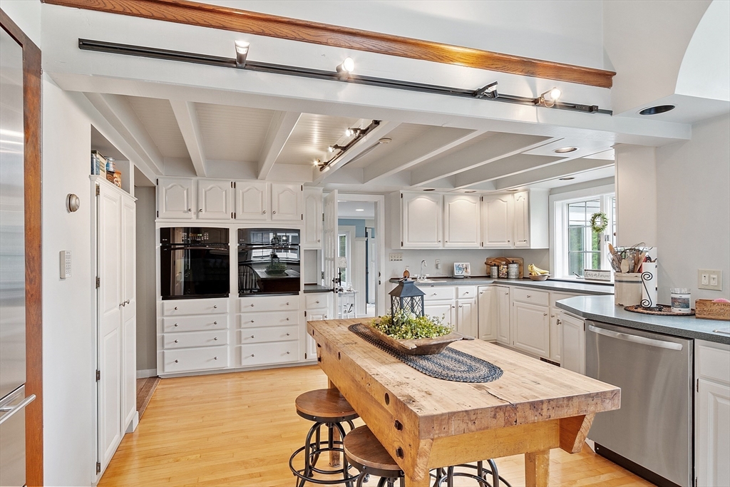 10 Garrison Street Groveland, MA 01834 - Photo 5 of 42 a kitchen with stainless steel appliances kitchen island granite countertop a table and chairs in it