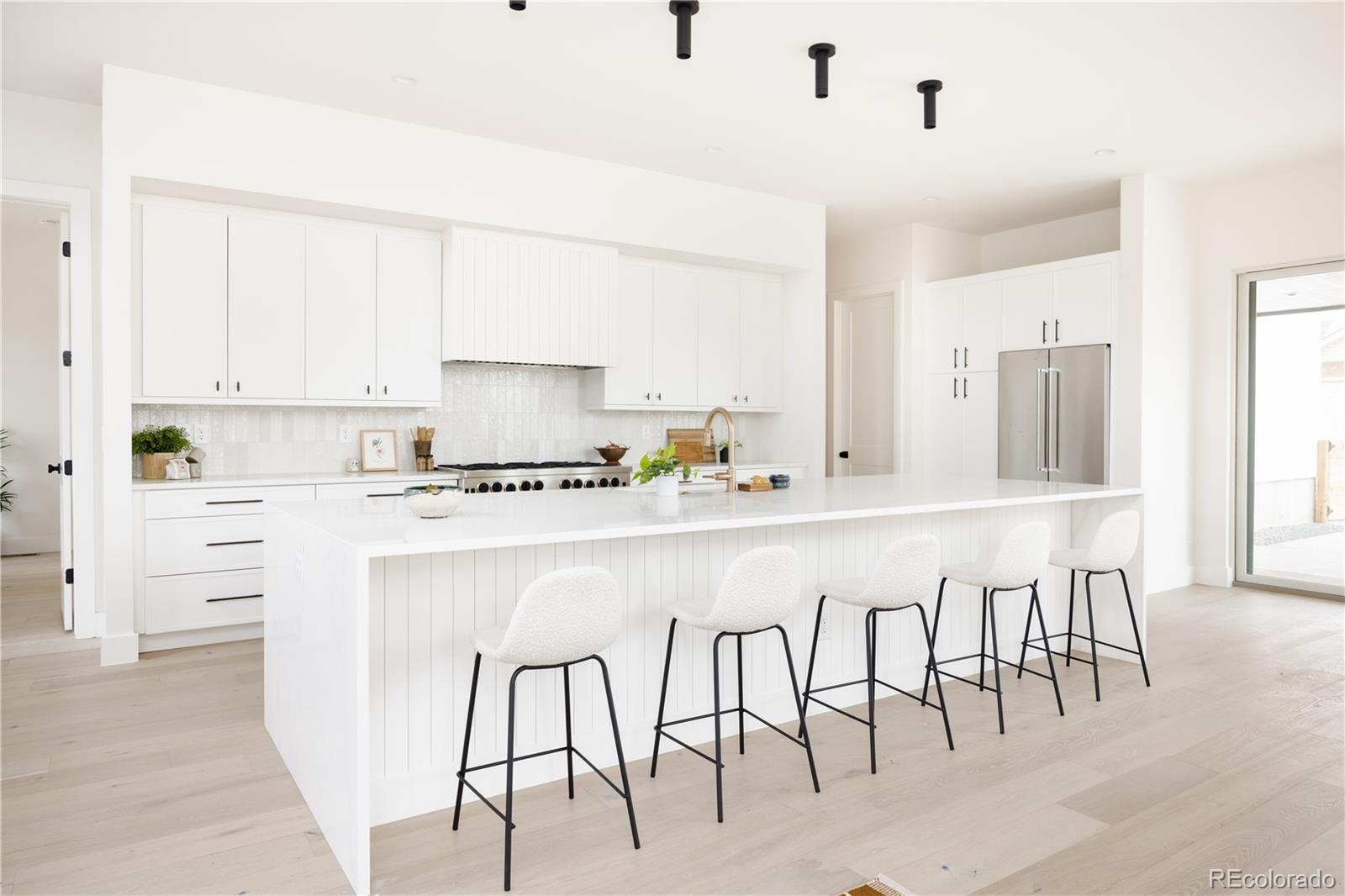 3076 Fenton Street Wheat Ridge, CO 80214 - Photo 10 of 37 a white kitchen with cabinets and chairs