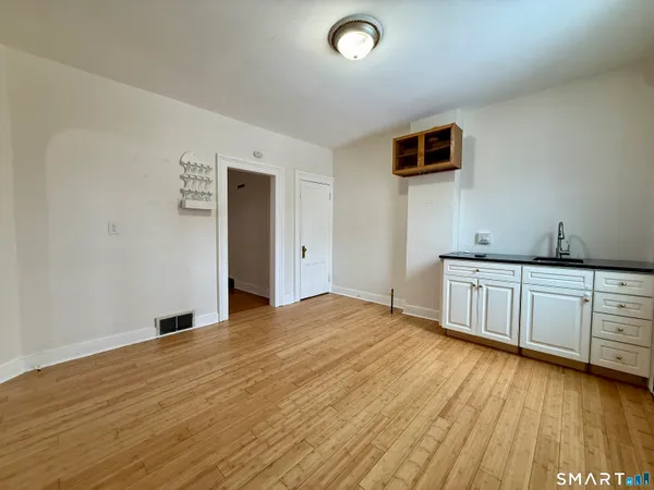 a view of empty room with wooden floor