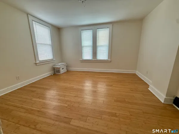 a view of empty room with wooden floor