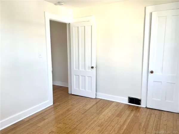 a view of an empty room with wooden floor