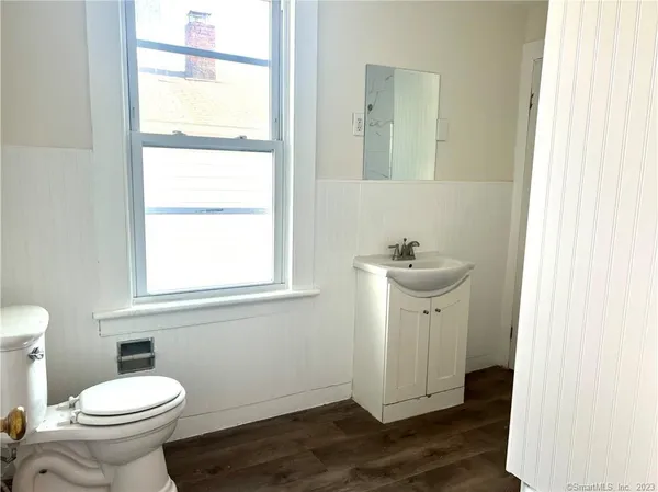 a bathroom with a sink a toilet and a mirror