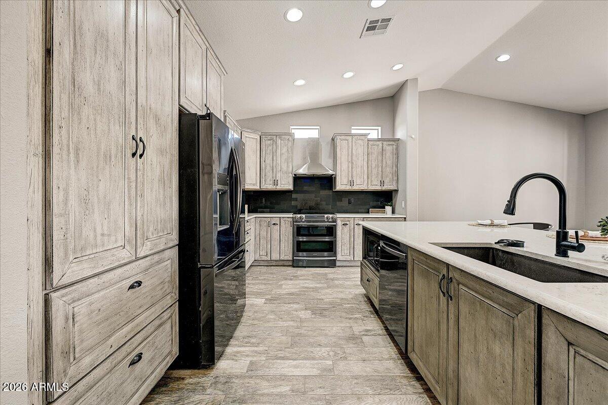 7624 North Citrus Road Waddell, AZ 85355 - Photo 16 of 57 a kitchen with stainless steel appliances a refrigerator sink and cabinets