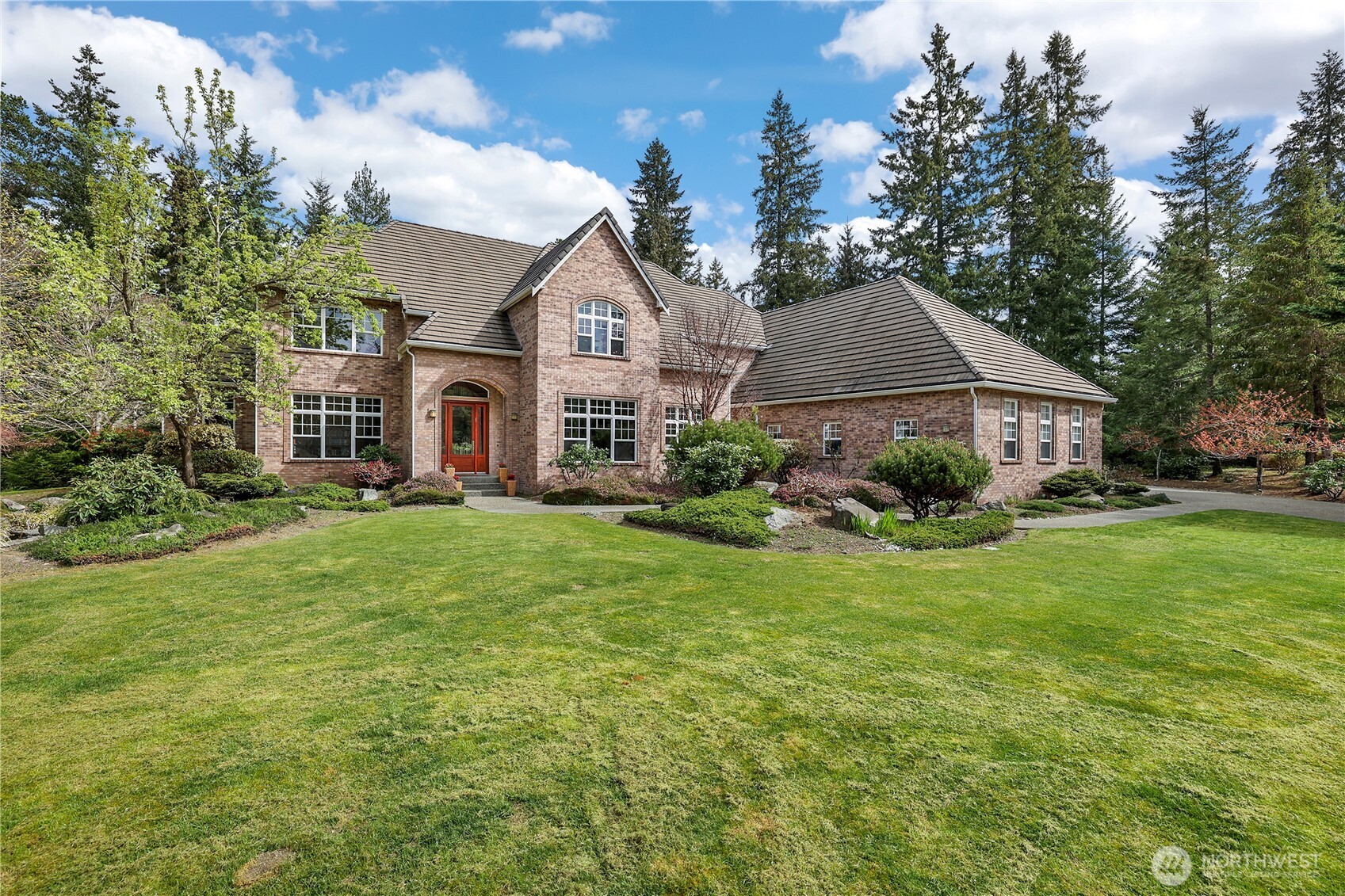 a view of a house with a big yard plants and large trees