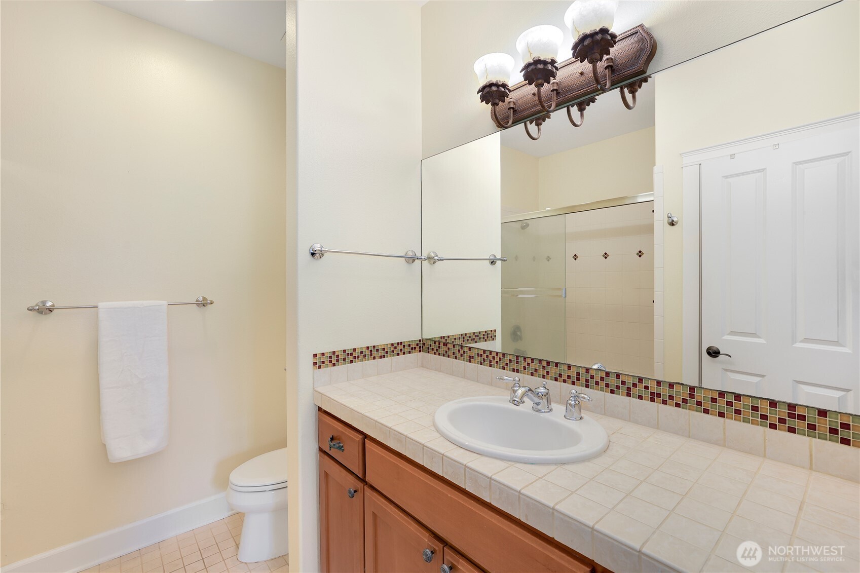 7007 Muirkirk Lane Southwest Port Orchard, WA 98367 - Photo 19 of 40 a bathroom with a granite countertop sink a toilet and a mirror