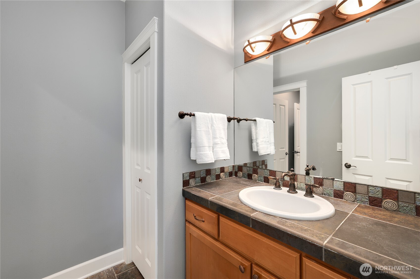 7007 Muirkirk Lane Southwest Port Orchard, WA 98367 - Photo 21 of 40 a bathroom with a sink and a mirror