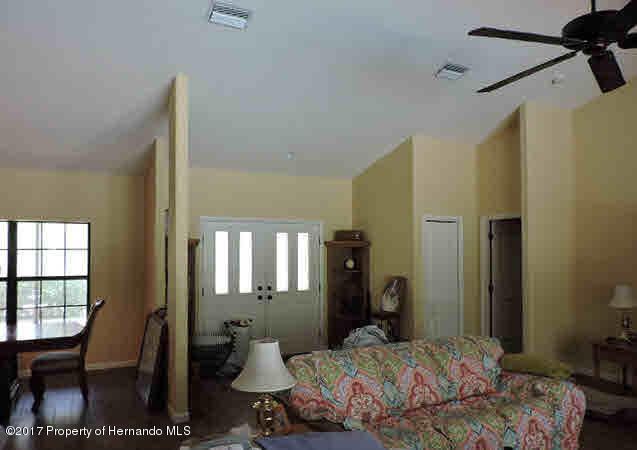 1156 Arlanie Road Brooksville, FL 34604 - Photo 25 of 27 a bedroom with a bed and wooden floor