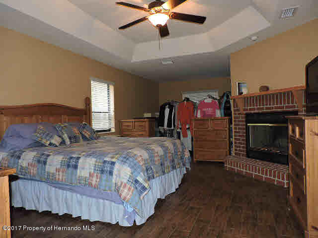 1156 Arlanie Road Brooksville, FL 34604 - Photo 15 of 27 a bedroom with bed and a fireplace