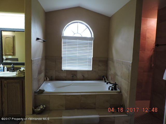 1156 Arlanie Road Brooksville, FL 34604 - Photo 18 of 27 a bathroom with a bathtub and a window