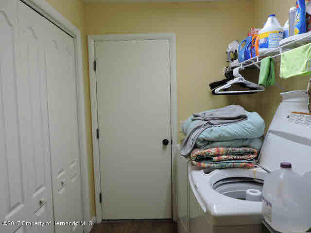 1156 Arlanie Road Brooksville, FL 34604 - Photo 22 of 27 a bedroom with a bed and cabinets