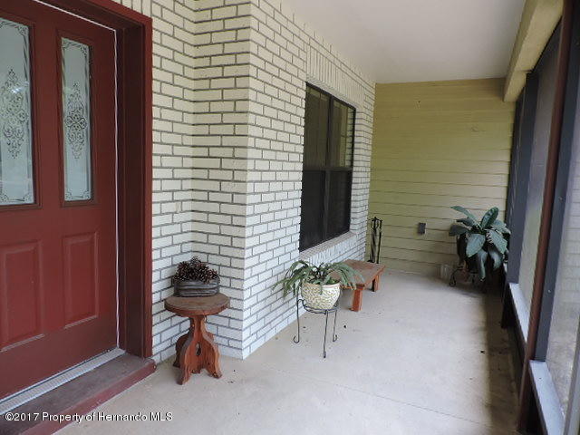1156 Arlanie Road Brooksville, FL 34604 - Photo 3 of 27 a backyard of a house with seating space