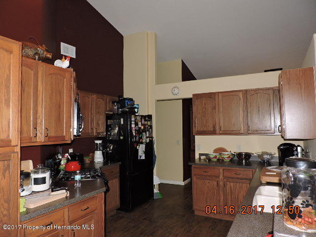 1156 Arlanie Road Brooksville, FL 34604 - Photo 9 of 27 a kitchen with stainless steel appliances granite countertop a refrigerator sink and cabinets