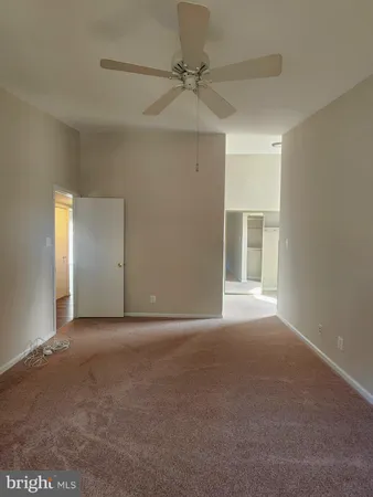 a view of a big room with windows and chandelier fan