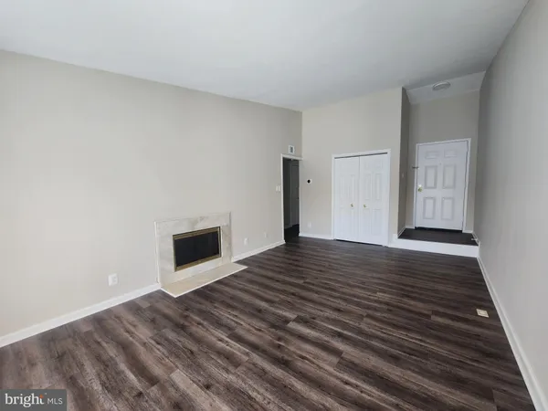 a view of empty room with wooden floor and fireplace