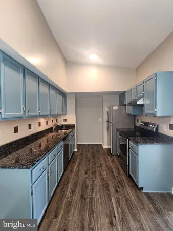 a large kitchen with stainless steel appliances granite countertop a stove and a sink