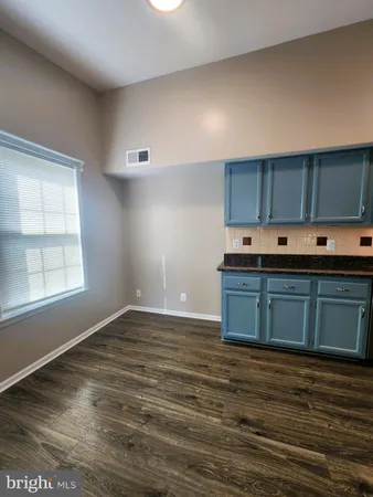 a kitchen with stainless steel appliances granite countertop a sink and cabinets with wooden floor