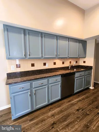 a kitchen with granite countertop a sink and cabinets
