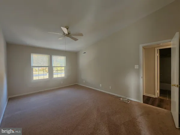 an empty room with a window and a ceiling fan