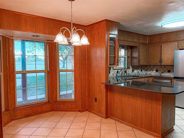 a kitchen with stainless steel appliances granite countertop a refrigerator a stove and a sink with granite countertops