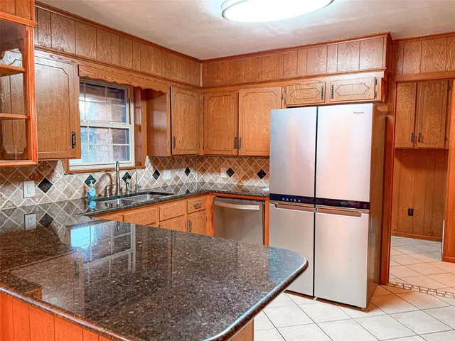 a kitchen with stainless steel appliances granite countertop a refrigerator and a sink