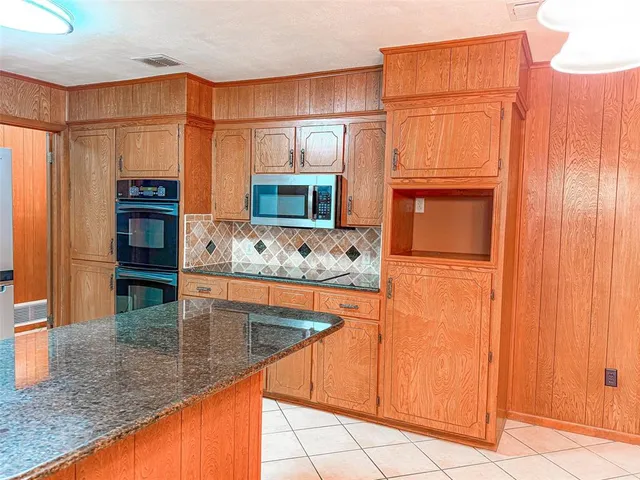 a kitchen with stainless steel appliances granite countertop a refrigerator and a stove top oven