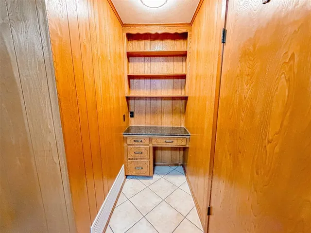 a view of an empty room with furniture and a window