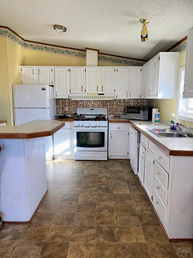805 7th Street Fowler, CO 81039 - Photo 4 of 20 a large kitchen with stainless steel appliances granite countertop a stove a sink dishwasher and a refrigerator