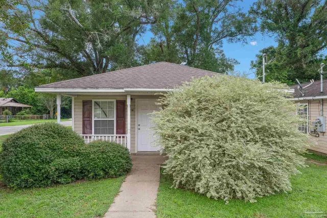 a front view of a house with a garden