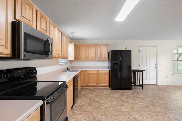 a kitchen with a refrigerator and a stove top oven