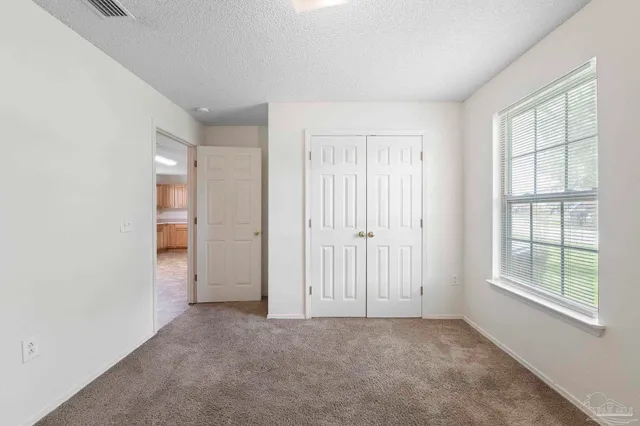 an empty room with windows and closet
