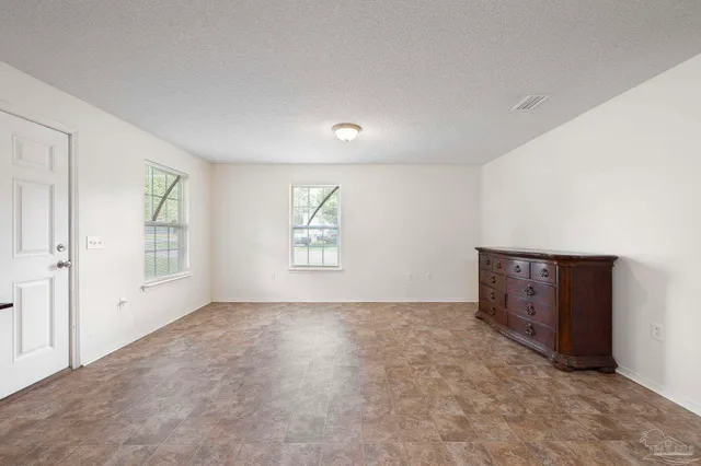 an empty room with windows and closet