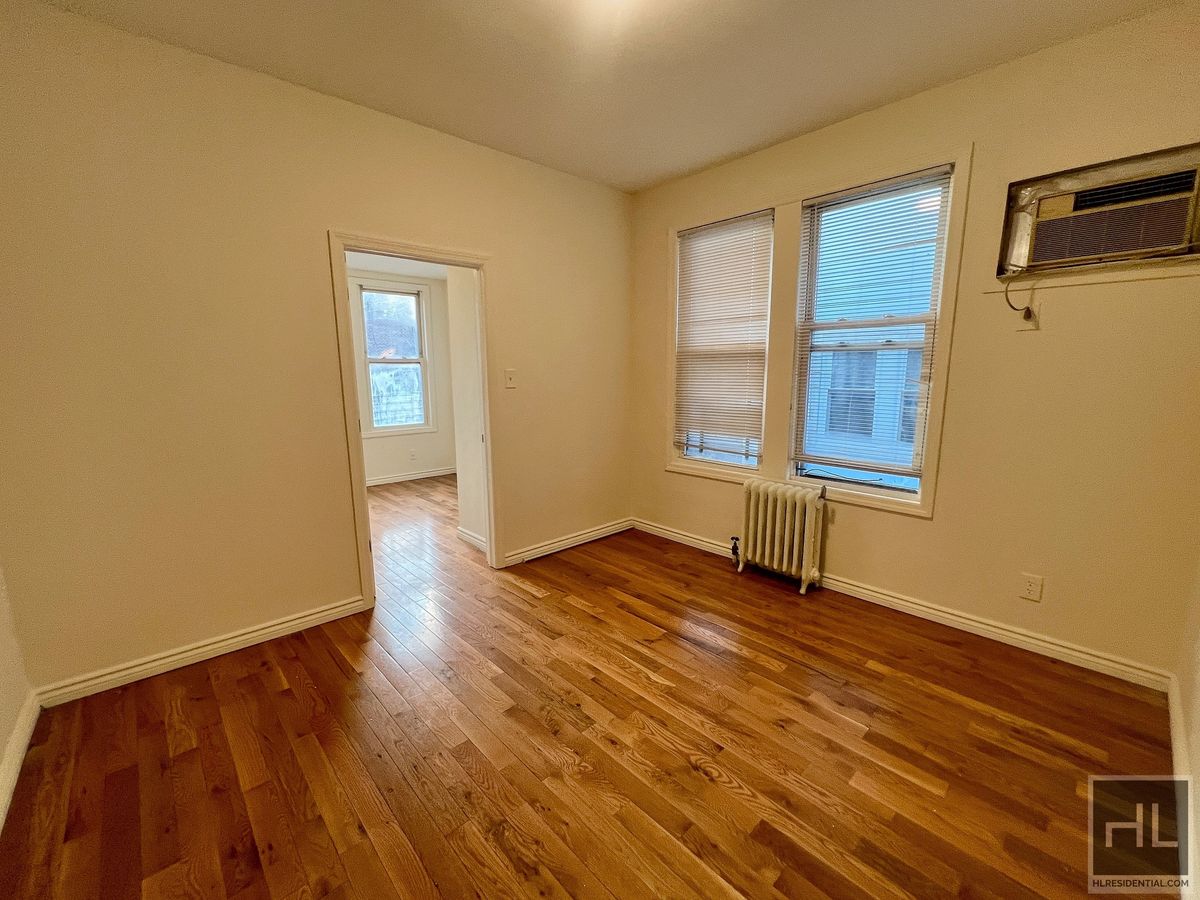 1339 East 91st Street, Unit 1B Brooklyn, NY 11236 - Photo 3 of 12 a view of an empty room with wooden floor and a window