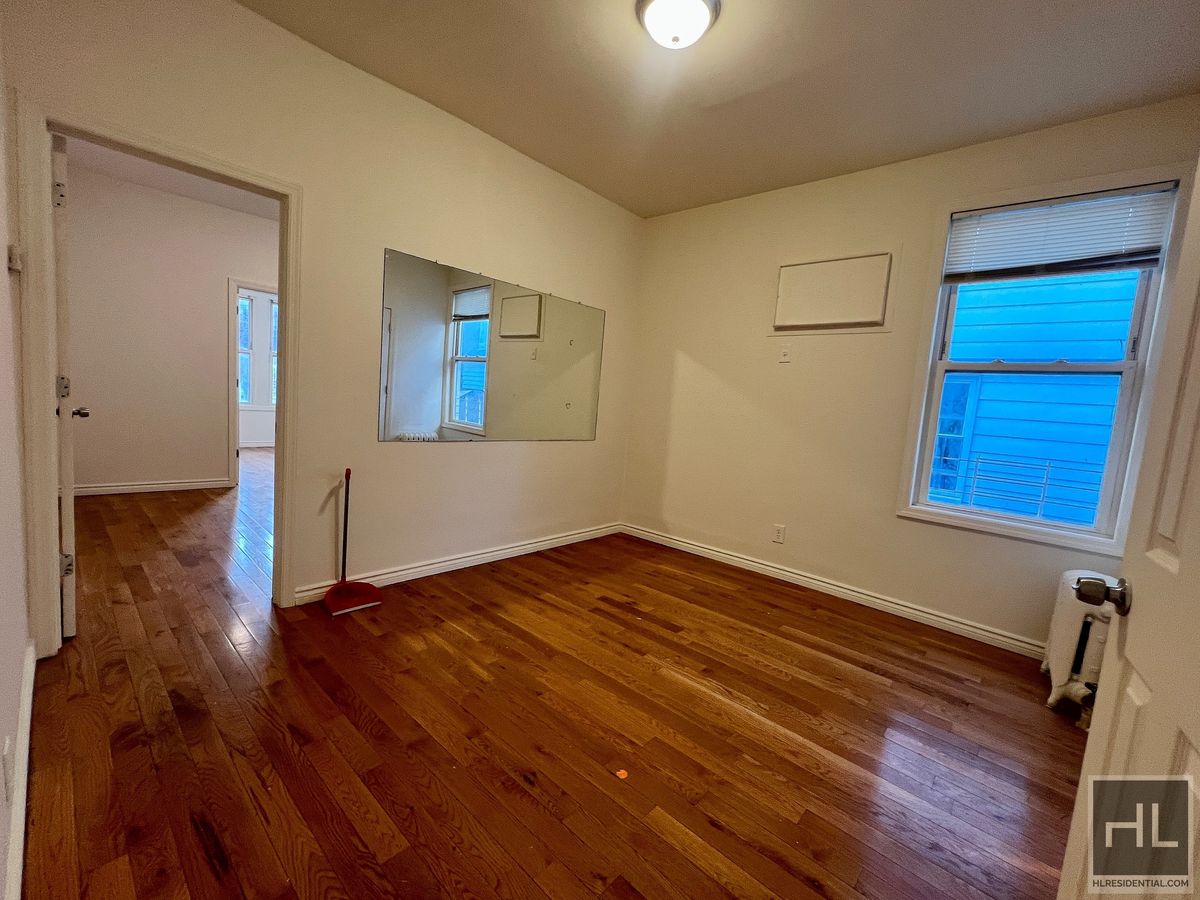 1339 East 91st Street, Unit 1B Brooklyn, NY 11236 - Photo 6 of 12 a view of an empty room with wooden floor and a window