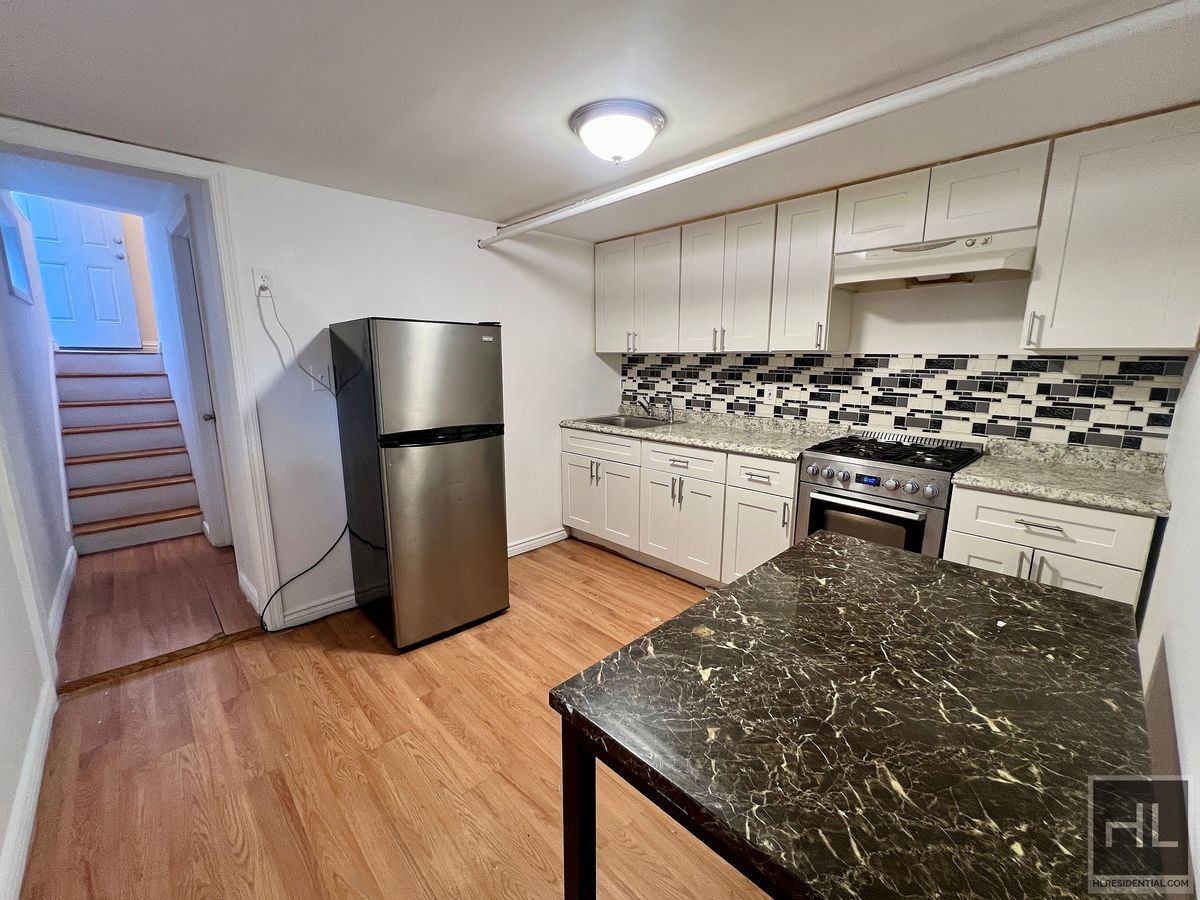 1339 East 91st Street, Unit 1B Brooklyn, NY 11236 - Photo 9 of 12 a kitchen with stainless steel appliances granite countertop a sink stove and refrigerator