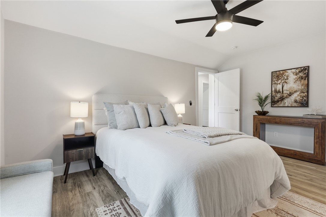 1 Brock Street Pelzer, SC 29669 - Photo 15 of 25 Vaulted ceilings elevate this serene primary bedroom, featuring a durable flooring and crisp white walls.