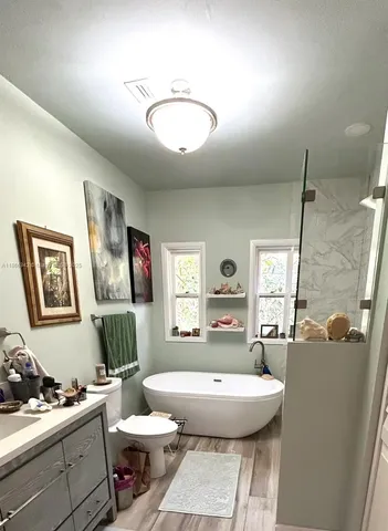 a white bath tub sitting in a bathroom next to a window