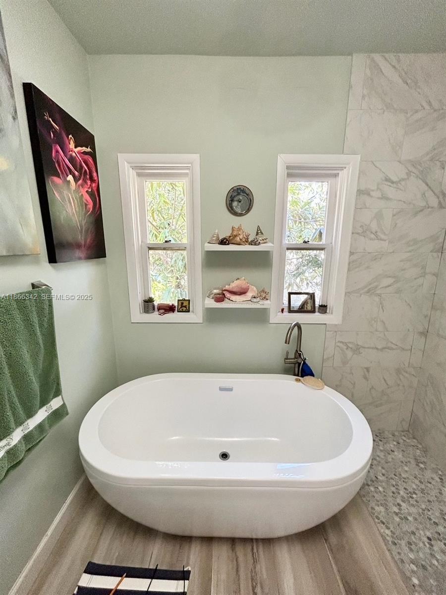 168 Northeast 44th Street Miami, FL 33137 - Photo 15 of 46 a white bath tub sitting in a bathroom next to a window