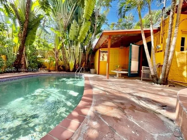 a view of swimming pool with a bench and trees in the background