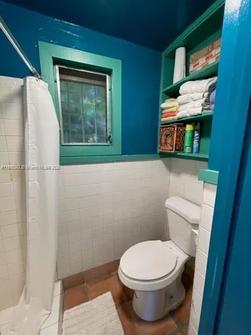 a bathroom with a toilet a sink a mirror and bathtub