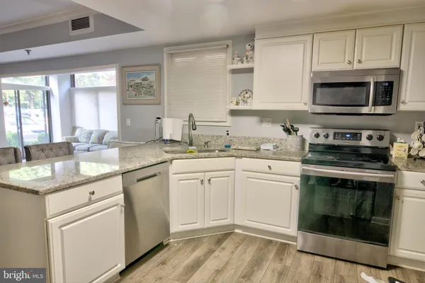 a kitchen with cabinets stainless steel appliances a sink and a microwave