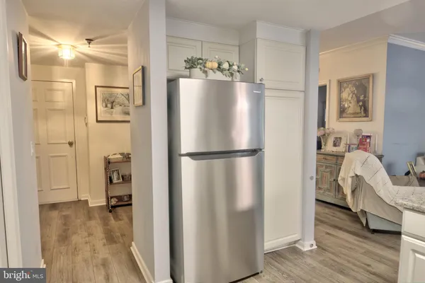 a kitchen with stainless steel appliances a refrigerator and wooden floor