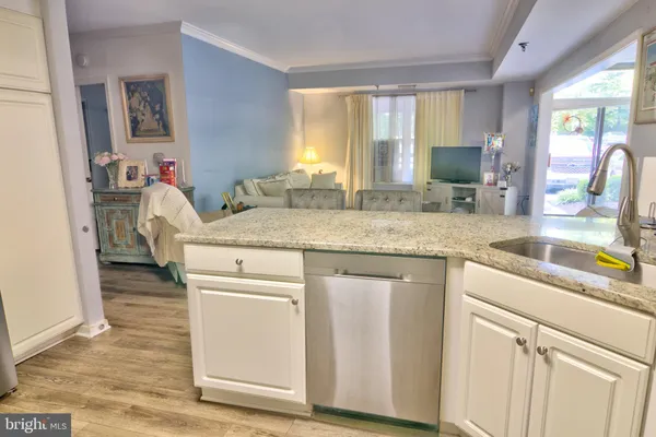 a kitchen with granite countertop a sink stove and cabinets
