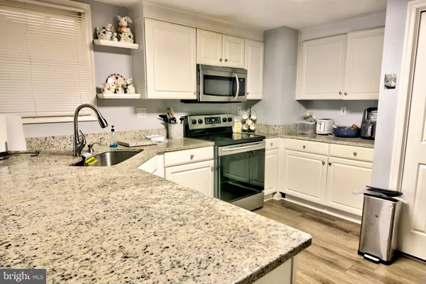 a kitchen with a sink stove and white cabinets