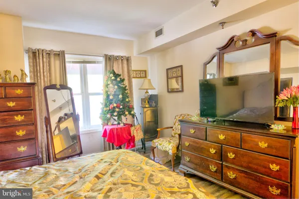 a bedroom with a bed and a flat tv screen on dresser
