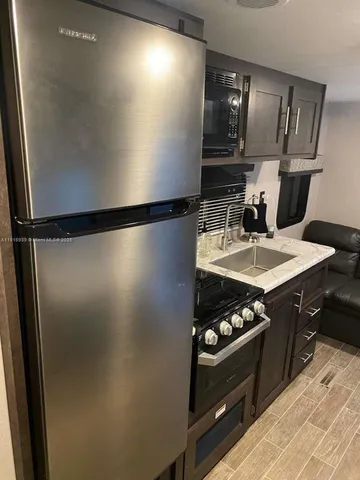 a kitchen with a sink and wooden floor