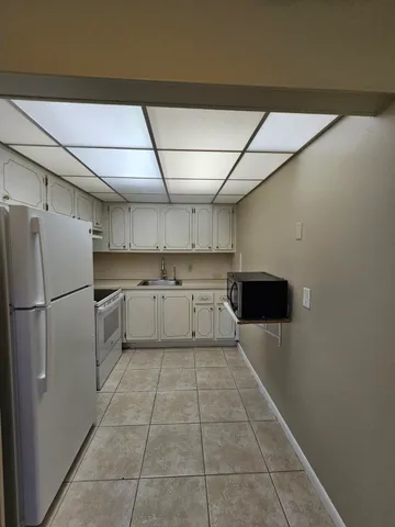 a kitchen with a cabinets a sink and white stainless steel appliances