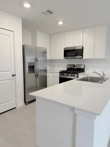 a kitchen with stainless steel appliances a refrigerator stove microwave and sink