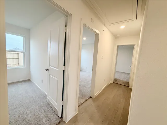 a view of a hallway with closet and wooden floor